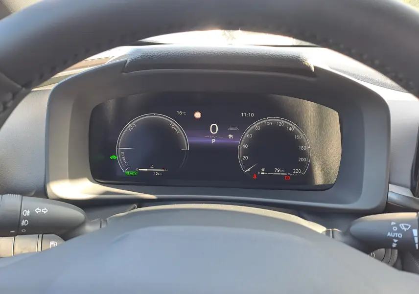 Vue depuis le poste de conduite du tableau de bord numérique du Toyota C-HR gris minéral, affichant les compteurs et indicateurs.