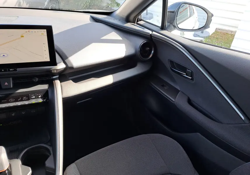 Intérieur côté passager du Toyota C-HR gris minéral 2025 avec écran tactile et aérateurs ronds design.