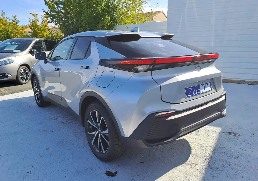 Toyota C-HR gris minéral vu 3/4 arrière droit, avec feux arrière LED et jantes bi-ton 18 pouces.