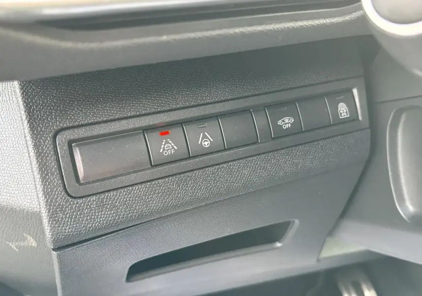 Gros plan sur les commandes d'aide à la conduite à gauche du volant dans l'habitacle du Peugeot 3008 blanc nacré 2024.