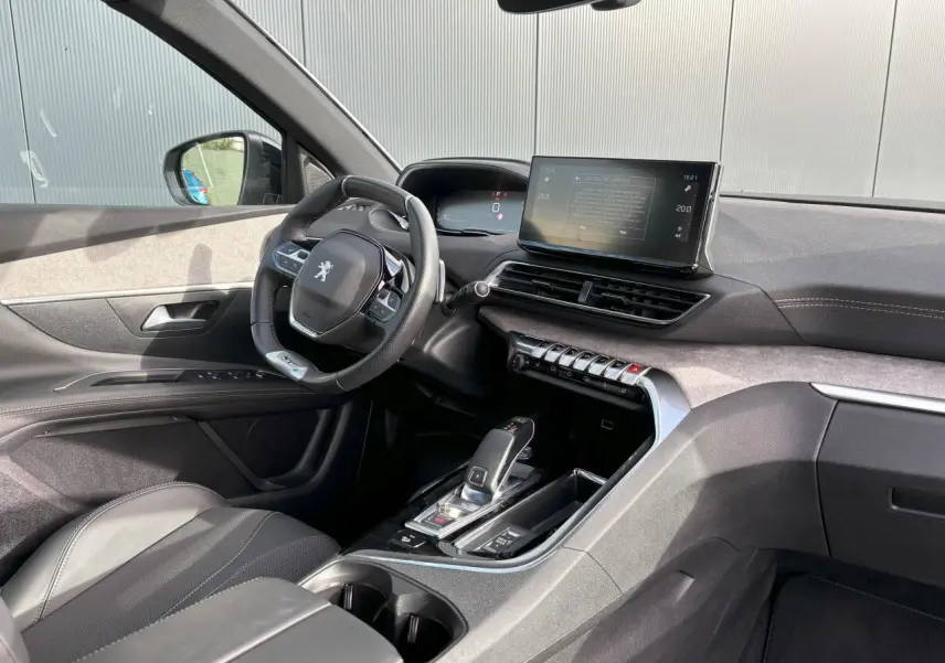 Vue intérieure côté conducteur du Peugeot 3008 2024, avec tableau de bord noir, écran tactile 10 pouces et volant compact cuir.