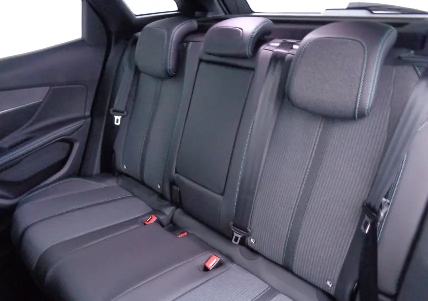 Vue intérieure du siège arrière du Peugeot 3008 2023 noir avec surpiqûres bleues et ceintures de sécurité visibles.