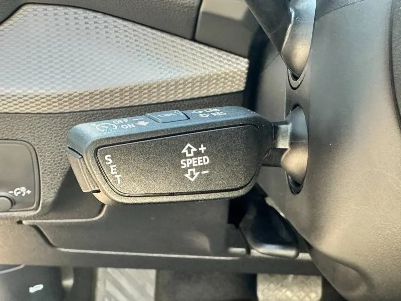 Le levier de régulateur de vitesse sur le côté gauche du volant d'un Audi Q2 noir Mythic 2023.
