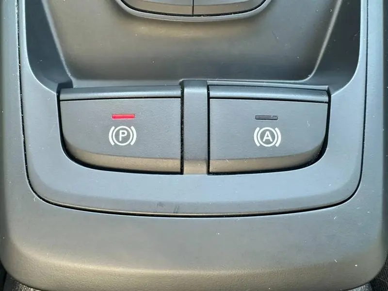 Gros plan sur les boutons de frein à main électronique et d'arrêt automatique du moteur dans l'Audi Q2 35 TFSI 2023.
