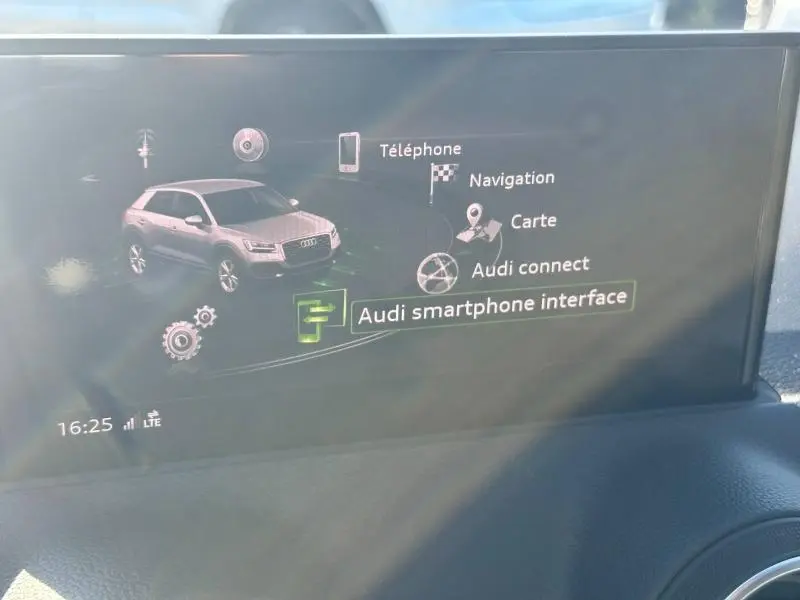 Écran central affichant l'interface multimédia d'un Audi Q2 2023 avec options connectées et navigation.