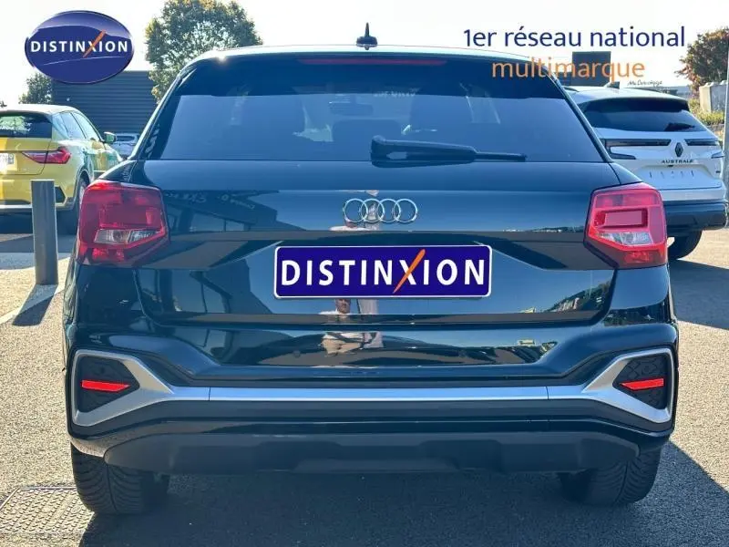 Vue arrière d'un Audi Q2 35 TFSI S line noir Mythic métallisé, avec feux rouges et logo Audi bien visibles.