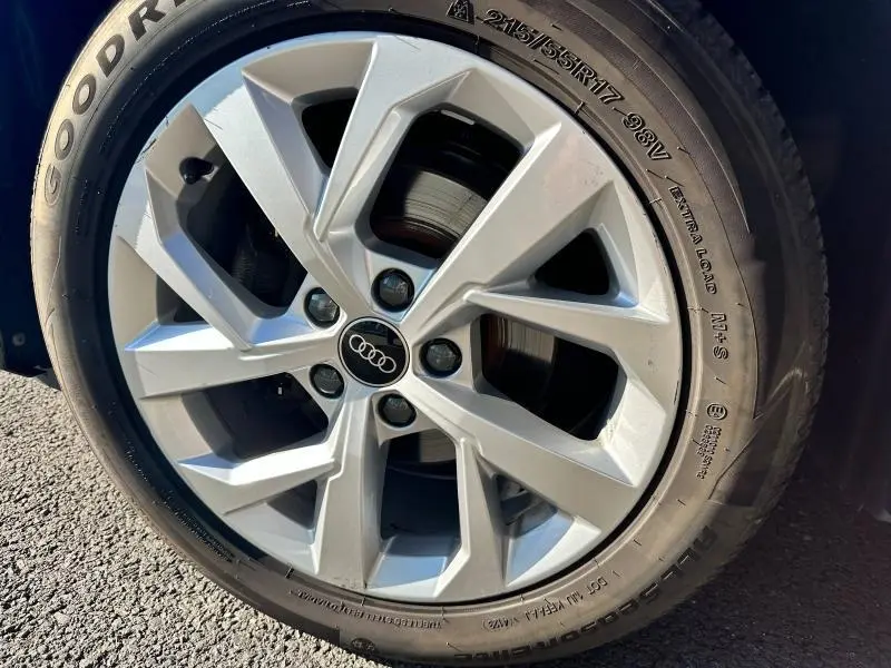 Gros plan sur la jante alliage argentée et pneu Goodyear du SUV Audi Q2 Noir Mythic métallisé 2023.