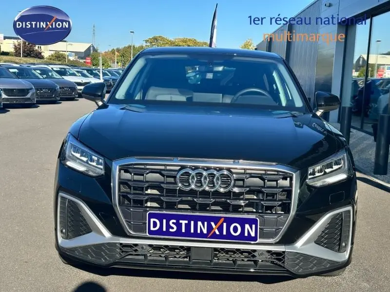 Vue frontale d'un Audi Q2 35 TFSI S line 2023 en noir Mythic métallisé avec calandre hexagonale et phares LED distinctifs.