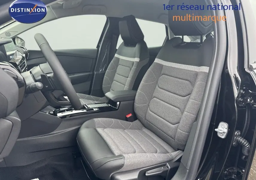 Vue intérieure côté conducteur d'une Citroën C4 2024 noir métal, sièges tissu gris et cuir noir avec console centrale moderne.