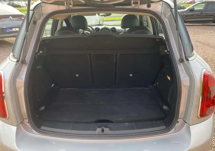 Coffre ouvert d'une MINI Countryman gris clair vue de l'arrière, montrant l'espace de chargement et l'intérieur des sièges arrière.
