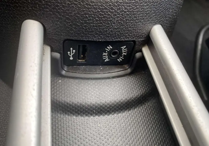 Gros plan sur la prise USB et AUX-IN du MINI Countryman gris clair, console centrale en plastique texturé noir.