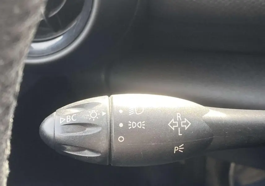 Gros plan sur la commande des clignotants et feux du MINI Countryman gris clair, intérieur noir.