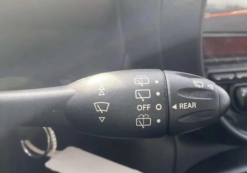 Gros plan sur la manette d'essuie-glace arrière du MINI Countryman gris clair de 2015, avec commandes visibles.