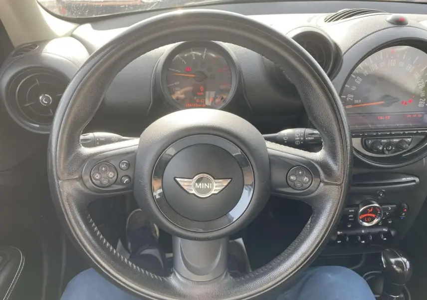 Vue centrée sur le volant en cuir noir d'une MINI Countryman 2015, avec tableau de bord et commandes visibles.