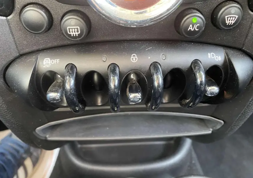 Gros plan sur les commandes à bascule noires du tableau de bord d'une MINI Countryman gris clair de 2015.