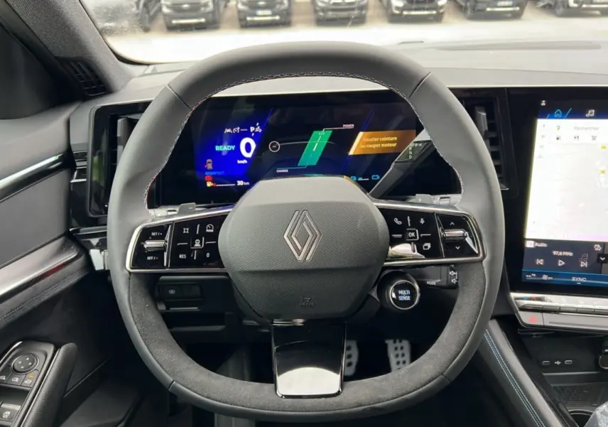 Vue intérieure centrée sur le volant du Renault Austral E-Tech 200 Esprit Alpine Plus avec tableau de bord numérique et écran tactile.