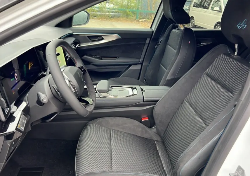 Intérieur côté conducteur du Renault Austral E-Tech 200 Esprit Alpine Plus 2025, sièges noirs avec surpiqûres bleues et logo Alpine.