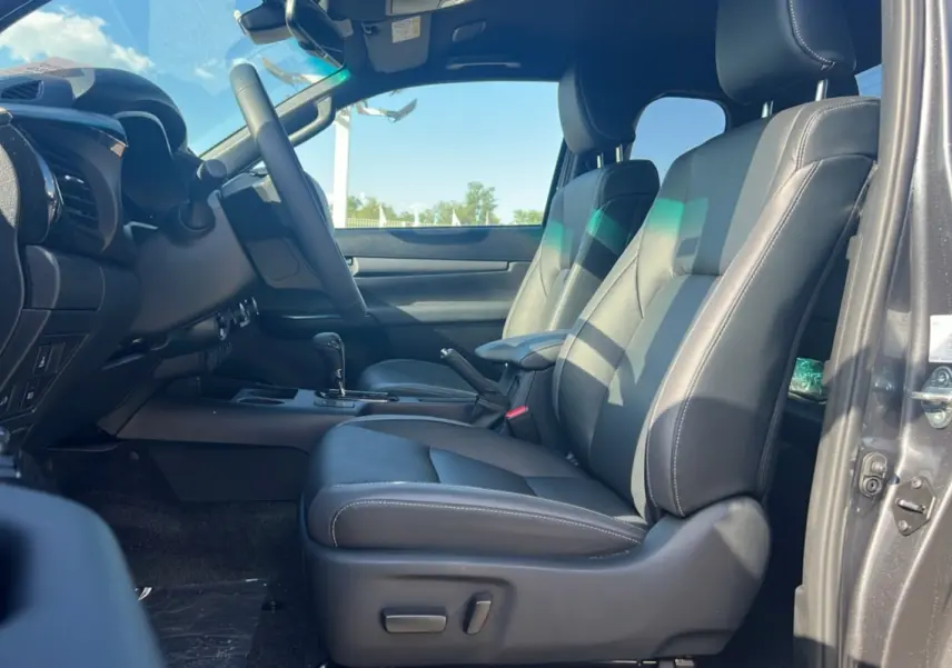 Intérieur du Toyota Hilux 4x4 Invincible 2025 en gris atlas, vue côté conducteur sur les sièges en cuir noir.