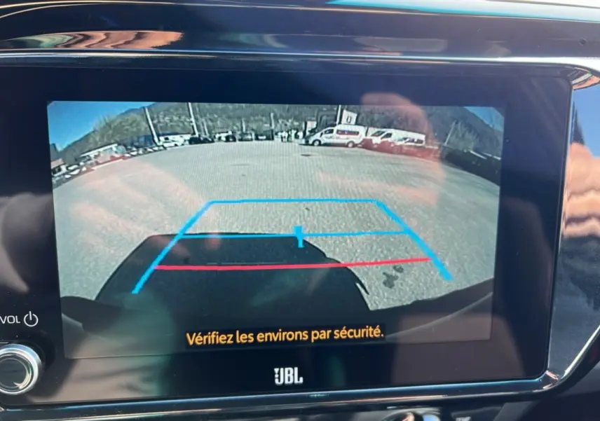 Vue caméra de recul du Toyota Hilux 4x4 gris atlas 2025 avec lignes d'aide au stationnement sur écran JBL.