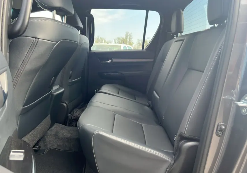 Vue intérieure sur la banquette arrière en cuir noir du Toyota Hilux 2025 gris atlas, côté droit ouvert.