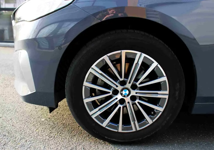 Gros plan sur la roue avant gauche d’une BMW Série 2 Active Tourer gris Nardo métal, jante alliage multibranches.