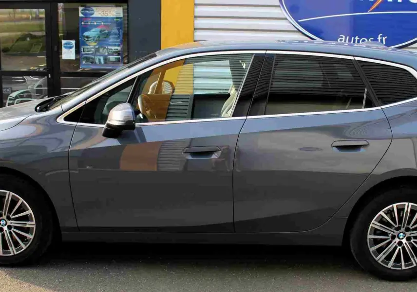 Vue de profil côté gauche d'une BMW Série 2 Active Tourer gris Nardo métallisé avec jantes alliage 17 pouces.