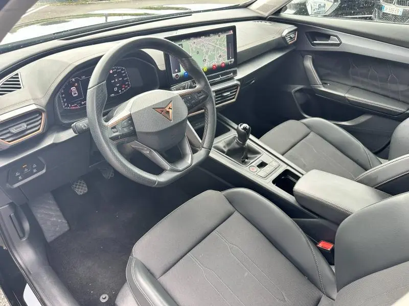 Vue intérieure côté conducteur du CUPRA Formentor 1.5 TSI 2024 avec volant sport, écran tactile et sellerie noir Asphalte.