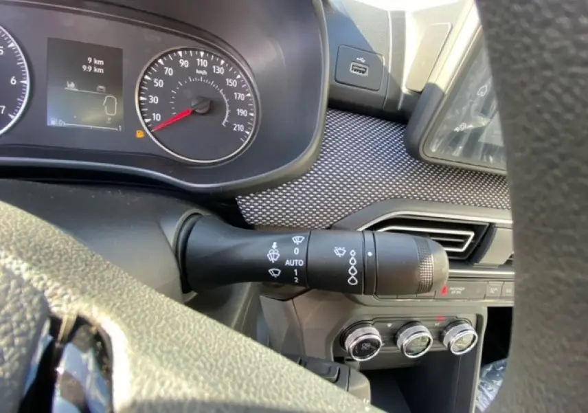 Gros plan sur le commodo d'essuie-glace à gauche du volant dans l'habitacle gris de la Dacia Logan 2022.