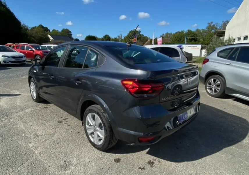 Vue 3/4 arrière droite d'une Dacia Logan gris foncé 2022 avec feux arrière LED et antenne toit.