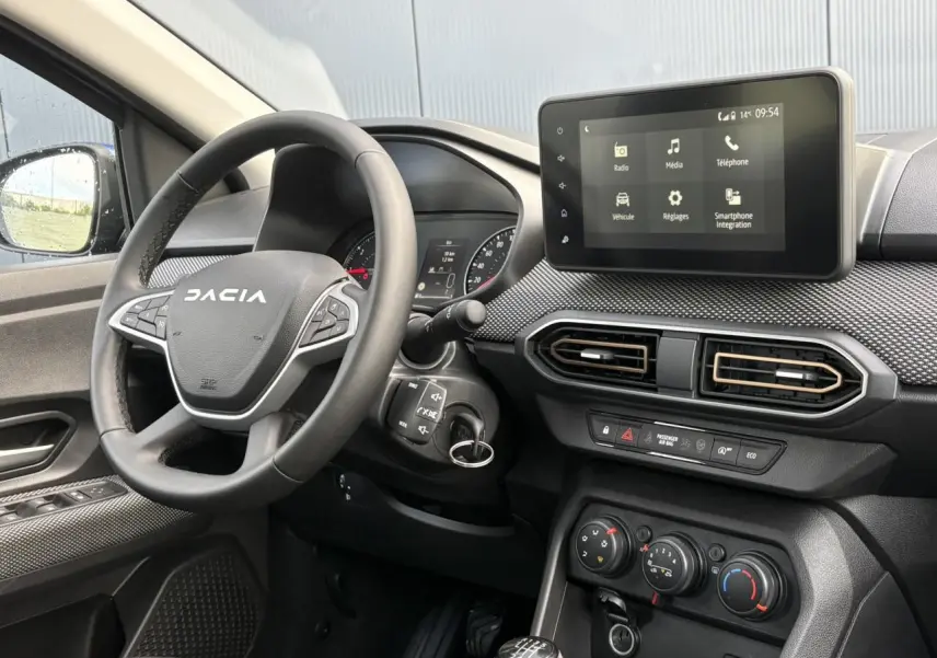 Vue intérieure côté conducteur du tableau de bord du Dacia Sandero Stepway 2025 avec écran tactile et volant noir.