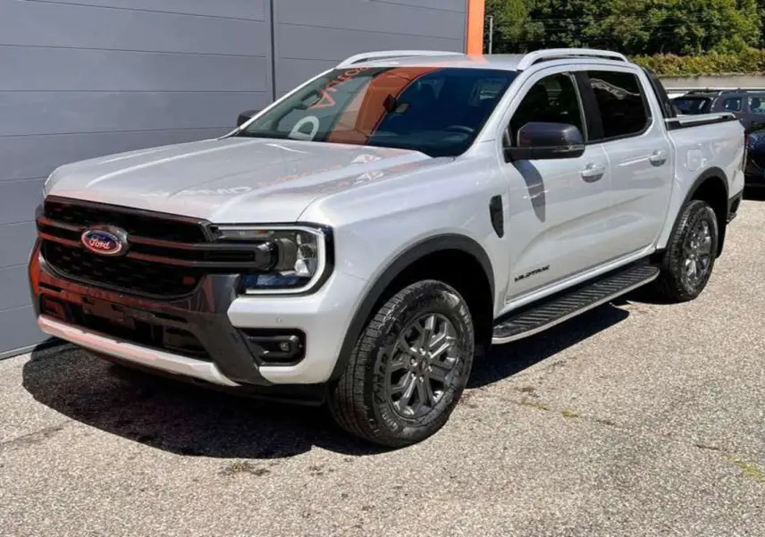 Ford Ranger 2025 gris iconic en 3/4 avant droit, avec calandre noire et jantes alliage foncé Wildtrak Plus.