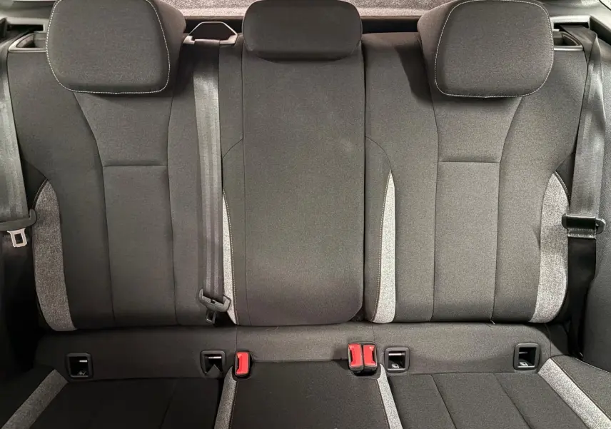 Vue intérieure de la banquette arrière du Skoda Kamiq 2025, sièges tissu gris avec ceintures et appuie-têtes.