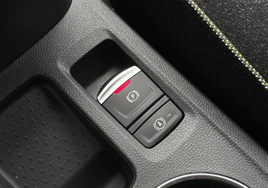 Gros plan sur la console centrale noire du Renault Captur 2026, avec commandes frein à main électrique et auto-hold.