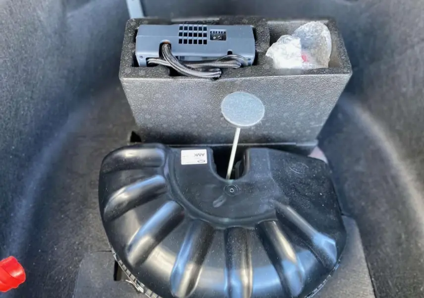 Gros plan sur le caisson noir de rangement dans le coffre du Range Rover Sport SVR 2016, avec accessoires visibles.