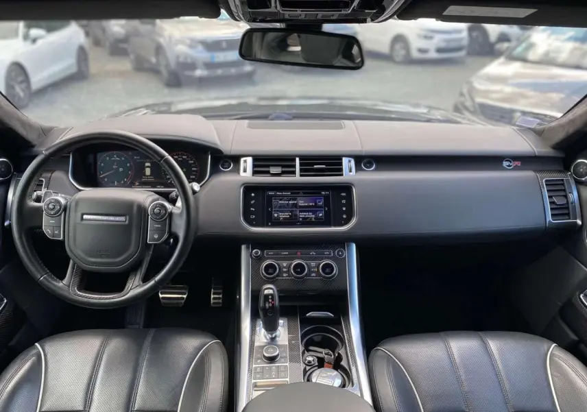Intérieur noir du Range Rover Sport SVR 2016 vu de face, avec volant cuir, console centrale et tableau de bord numérique.