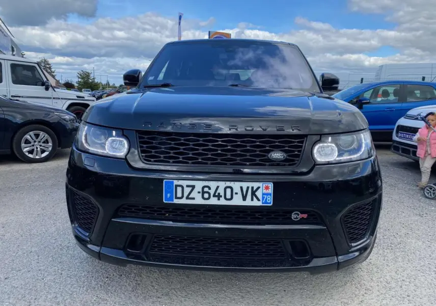 Vue frontale d'un Range Rover Sport noir 2016 avec calandre noire et badge SVR visible sur le pare-chocs.