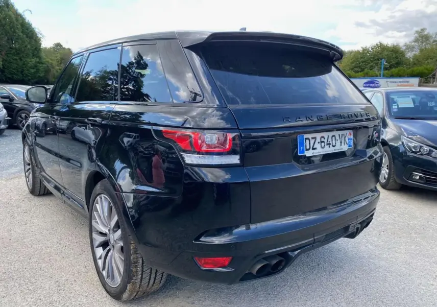 Vue 3/4 arrière droite d'un Range Rover Sport SVR noir avec jantes 22 pouces et quadruple sortie d'échappement.