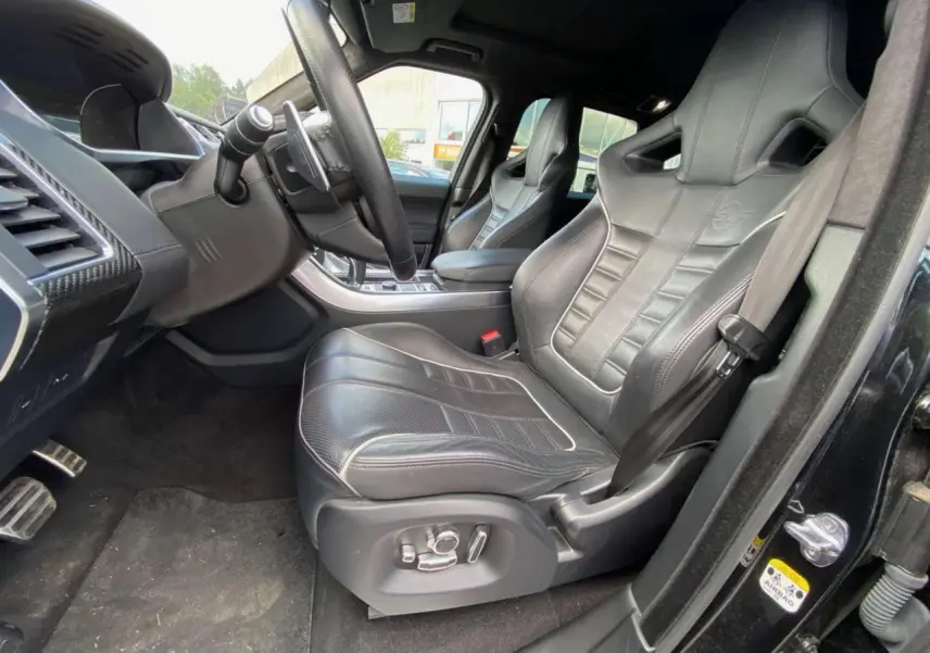 Intérieur noir du Range Rover Sport SVR 2016, vue côté conducteur sur sièges sport en cuir avec logo SVR embossé.