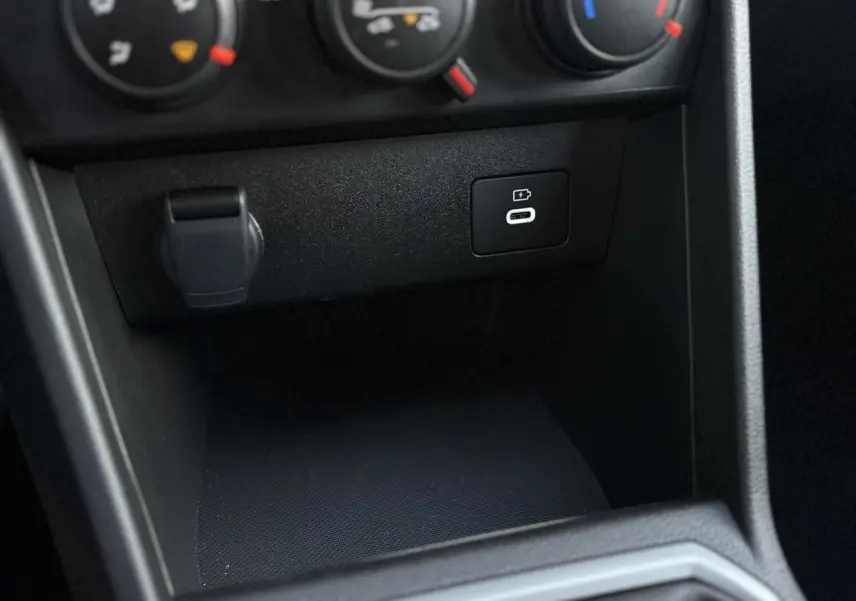 Gros plan sur la console centrale noire de la Dacia Sandero Stepway 2025 montrant la prise USB-C de recharge.