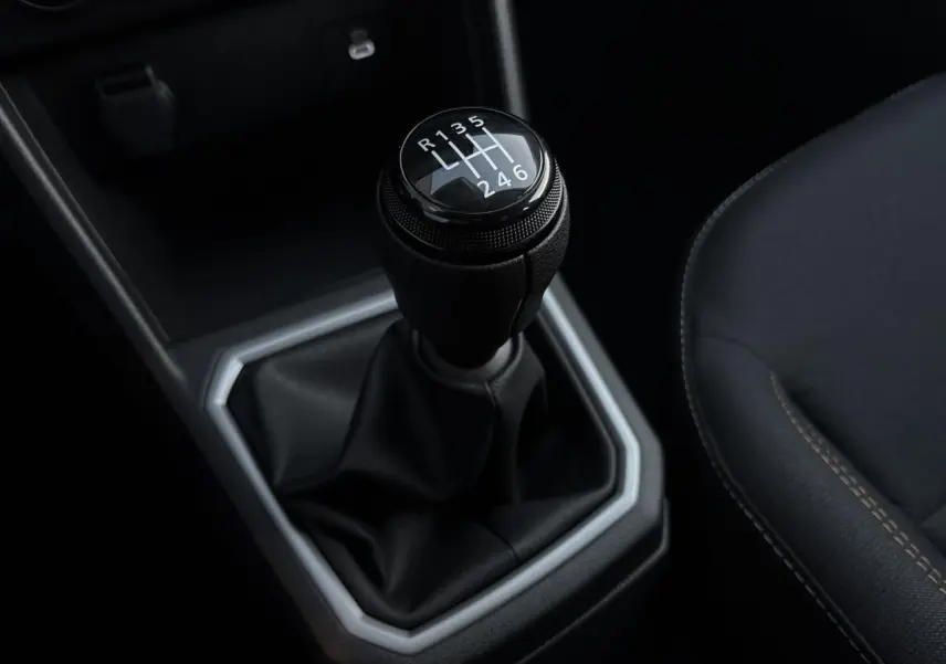 Gros plan sur le levier de vitesses manuel noir de la Dacia Sandero Stepway 2025, avec coutures marron du siège adjacent.