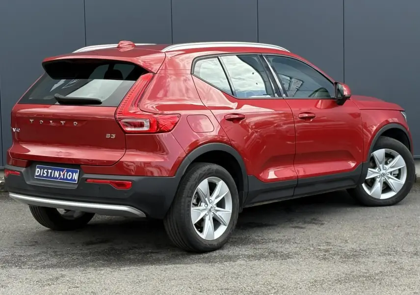 Volvo XC40 B3 MHEV rouge Fusion vue 3/4 arrière côté gauche, avec jantes alliage 18 pouces et toit blanc.
