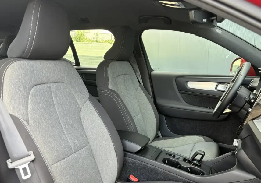 Vue intérieure côté droit du Volvo XC40 2024 avec sièges gris clair et volant noir visible.