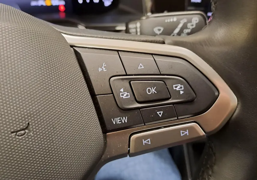 Gros plan sur les commandes multifonctions au volant côté gauche du Volkswagen Taigo 2024, finition VW Edition ++.