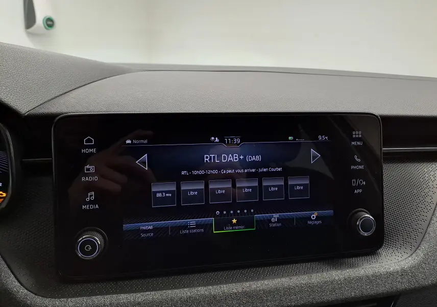 Écran tactile central du tableau de bord de la Skoda Scala 2025, affichant la radio numérique RTL DAB+ en intérieur noir.