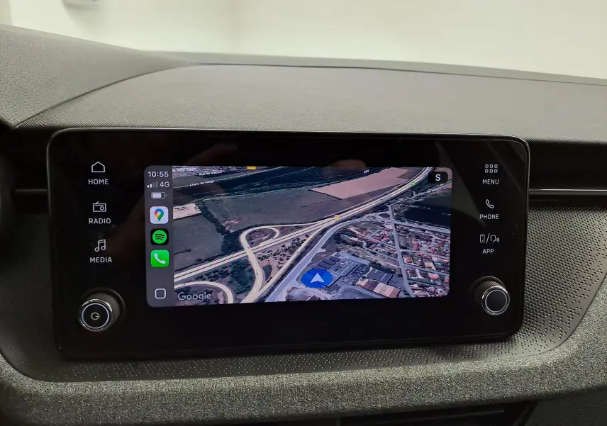 Écran tactile central du Skoda Scala 2025 en gros plan, affichant la navigation GPS avec interface noire et boutons latéraux.