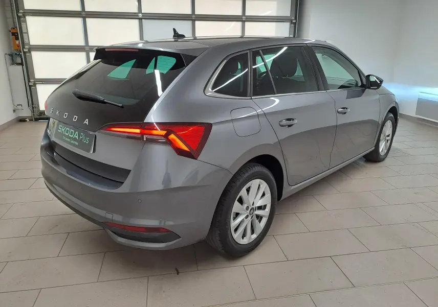 Vue 3/4 arrière droit d'une Skoda Scala 2025 gris graphite avec feux arrière allumés et caméra de recul visible.