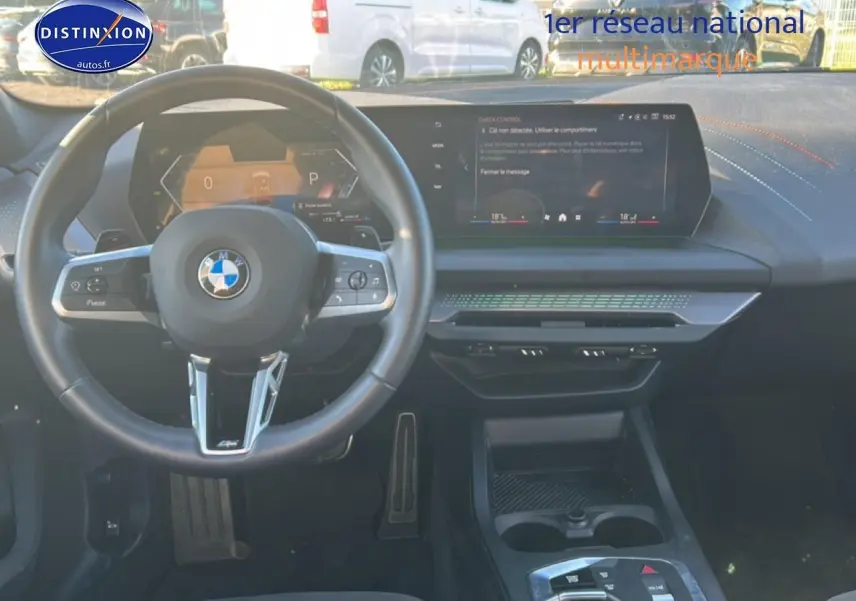 Vue intérieure frontale du tableau de bord et volant de la BMW Série 1 118da gris Skyscraper avec écran tactile et finition M Sport Pro.