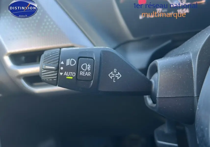 Gros plan sur la commande des phares et clignotants à gauche du volant dans une BMW Série 1 gris Skyscraper.