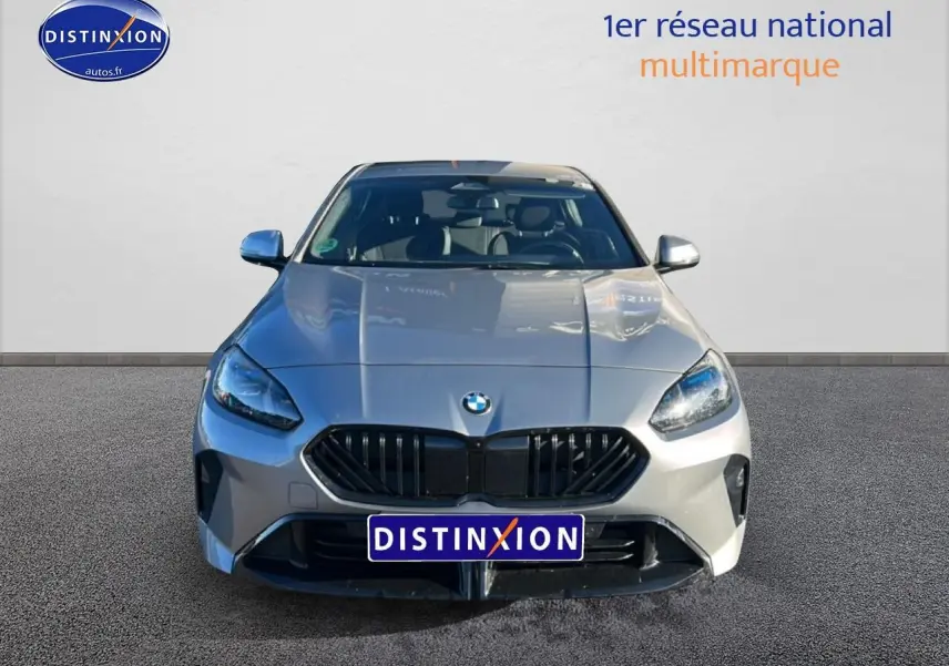 Vue avant d'une BMW Série 1 118da 2025 gris skyscraper avec calandre noire et phares LED allumés.
