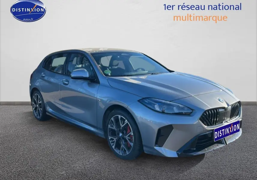 BMW Série 1 118da 2025 gris skyscraper vue 3/4 avant droit avec jantes 18 pouces bicolores et calandre noire.